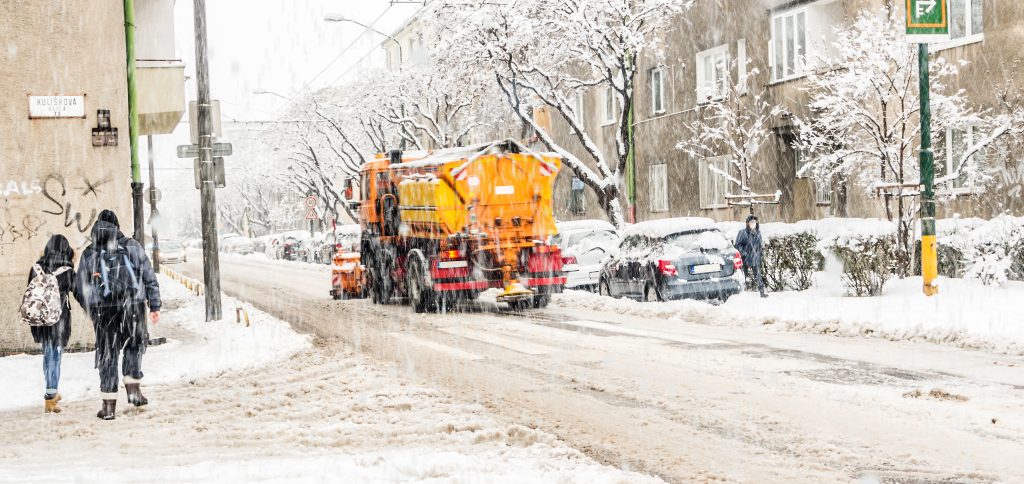 ENHANCING BUSINESS CONTINUITY AND REPUTATION - city street covered with snow during heavy winter storm or blizzard with snow plow clearing road for businesses - on hold marketing concept