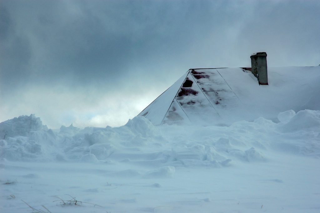 Hut after a snow storm, blizzard, covered in snow. Storm disaster relief concept - on hold marketing concept