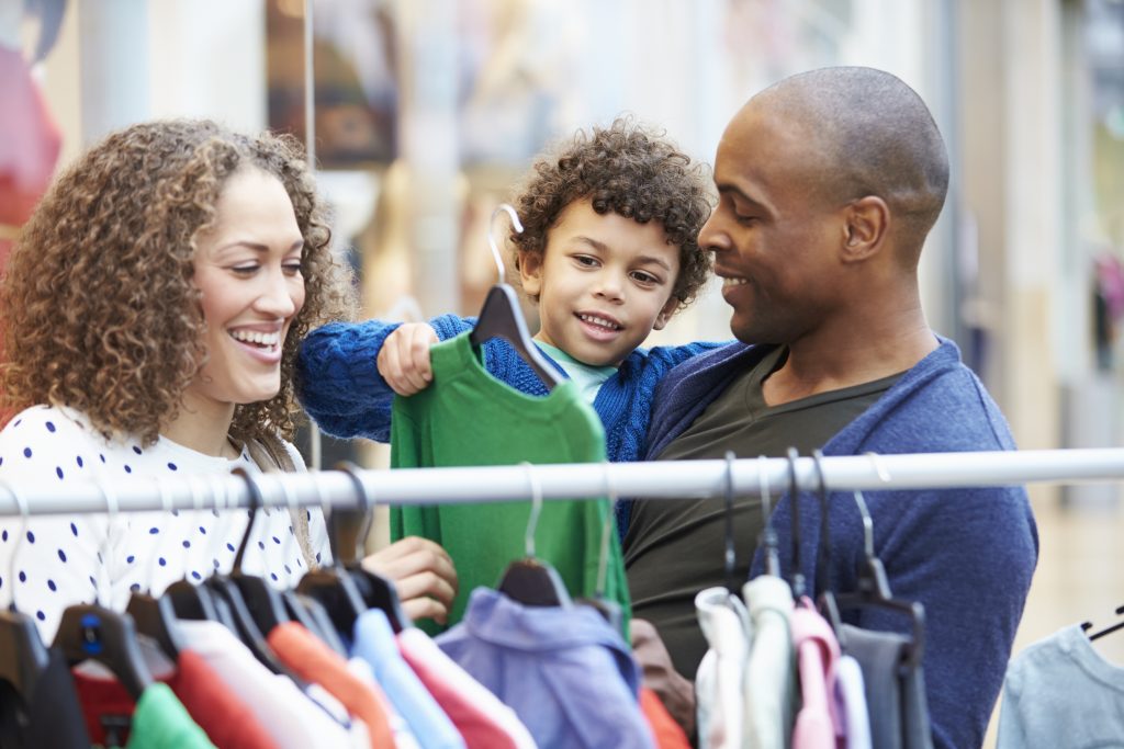 Family shopping in clothing store retail location, enjoying themselves and the overhead music in the location.