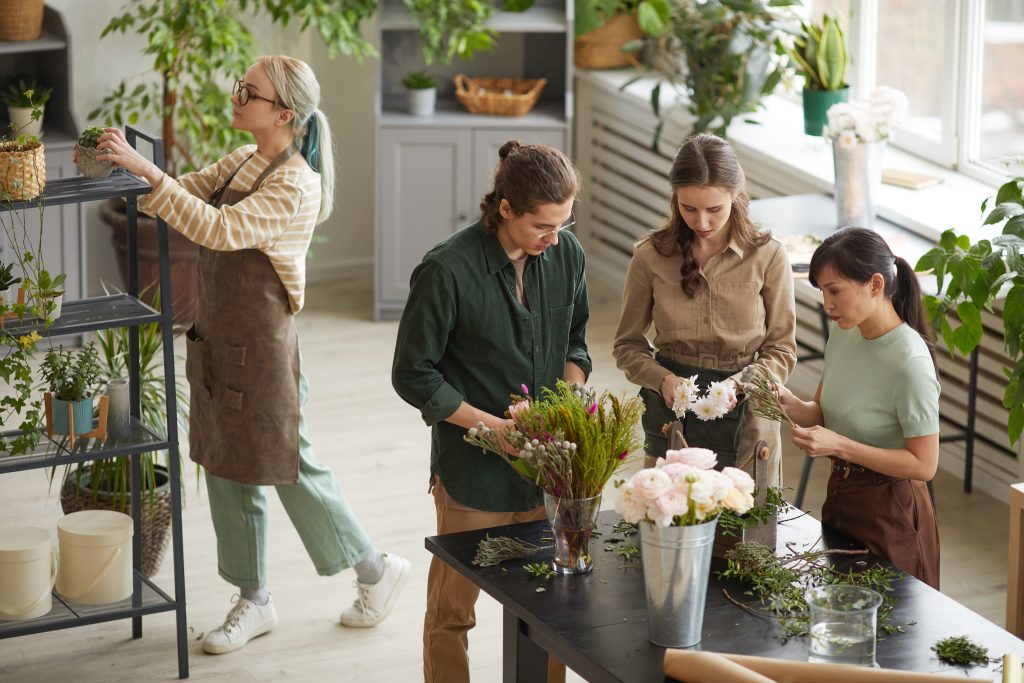 overhead marketing concept - Enhancing Customer Experience and Operations - customers and employees in florist shop demonstrating floral arrangements