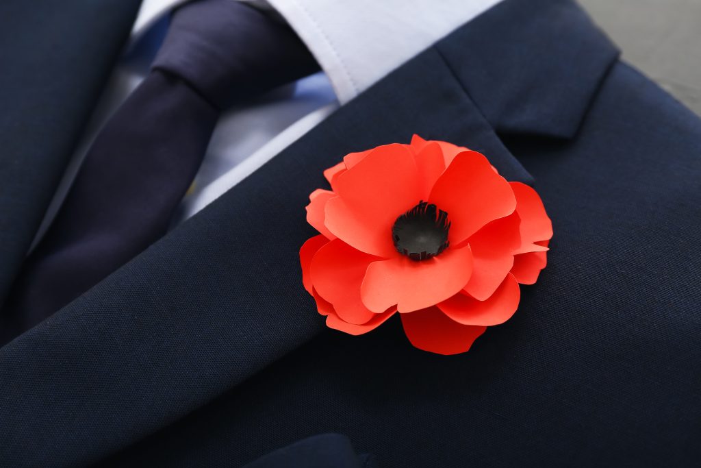 Business man in a suit with a poppy on the lapel, closeup on the flower - How/Why Businesses should observe Remembrance Day with Professional Voicing