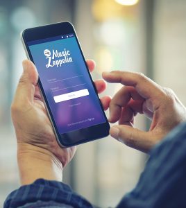 Mans hands holding smartphone with visible screen showing Music Zeppelin app login