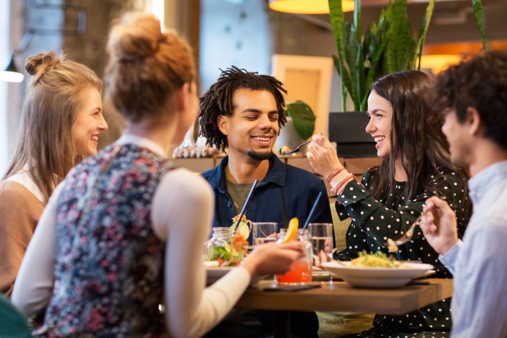 High-quality sound systems are crucial; poor sound quality can undermine the benefits of your audio strategy and negatively impact the customer’s dining experience - Group of friends enjoying a meal together at a restaurant