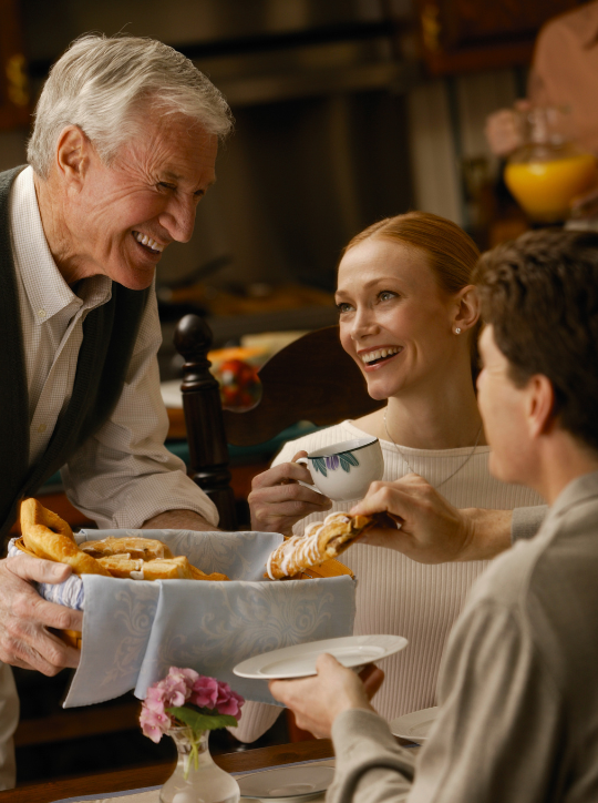 Creating a Welcoming Atmosphere with Overhead Music - Waiter serving pastries to smiling patrons